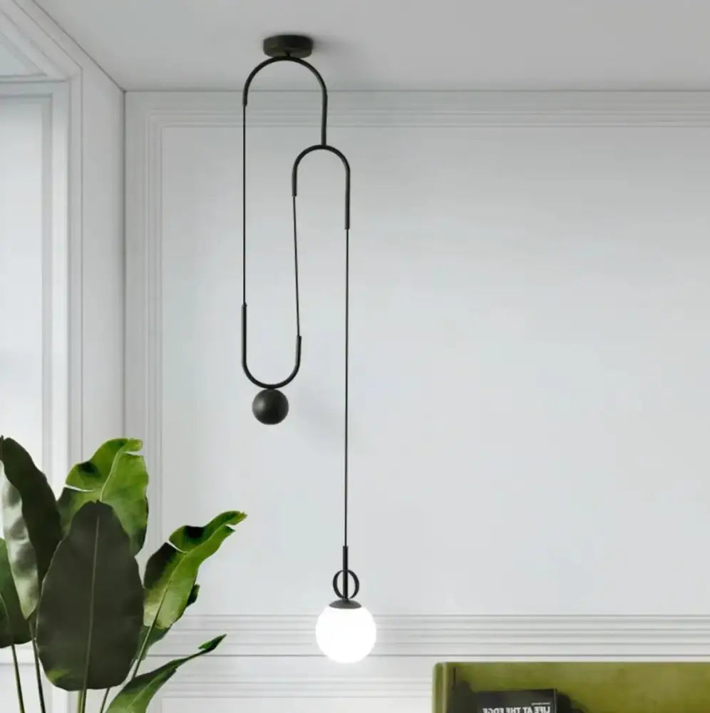 Black metal pendant lamp with sleek curved design and spherical bulb for modern brass golden glass ball decorbites pendant lamps