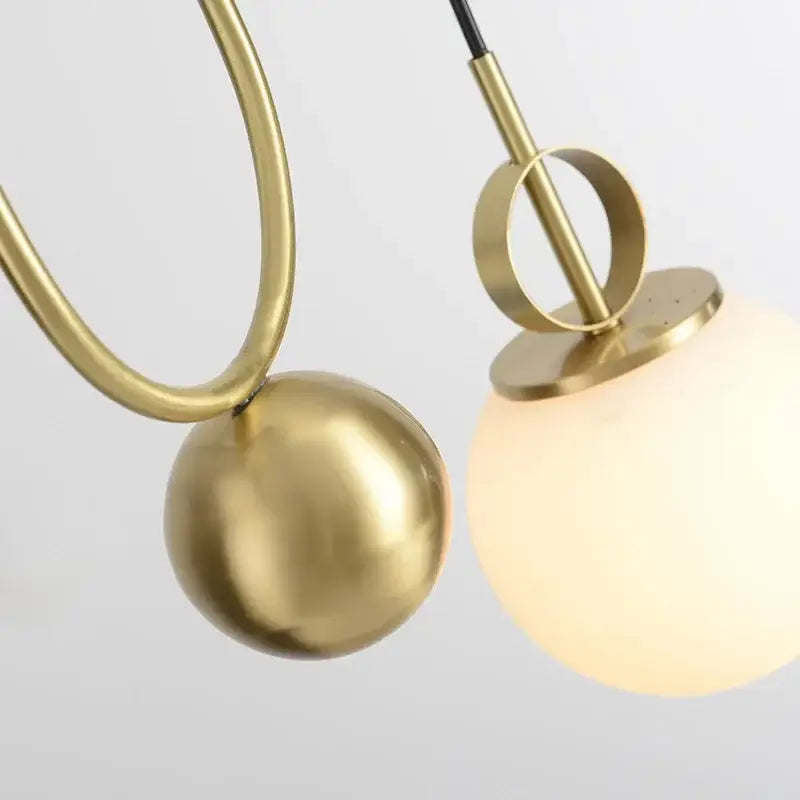 Modern brass golden glass ball pendant lamps featuring brass-finished spherical lights with frosted and metallic globes