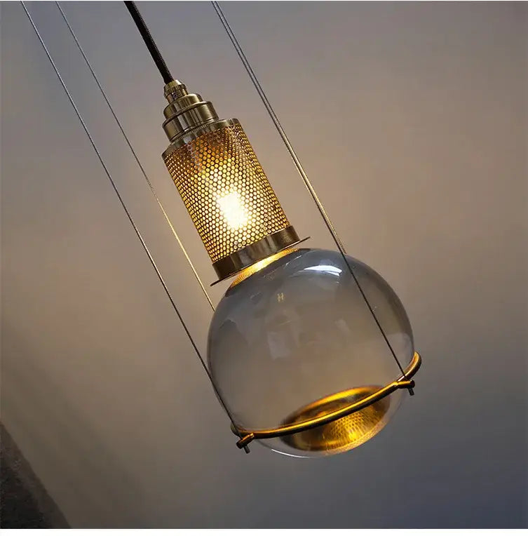 Modern brass honeycomb crystal ball led pendant light with clear glass globe and gold metal accents for dining room decorbites