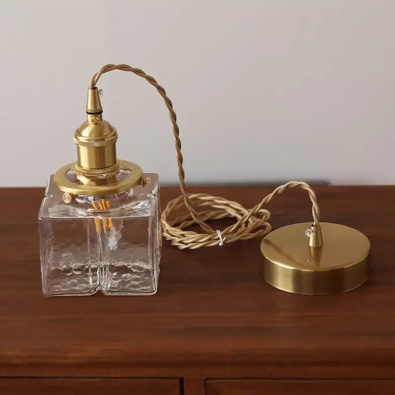 Modern brass ice cube glass pendant light with clear textured glass and brass-finished fixture for kitchen island decorbites