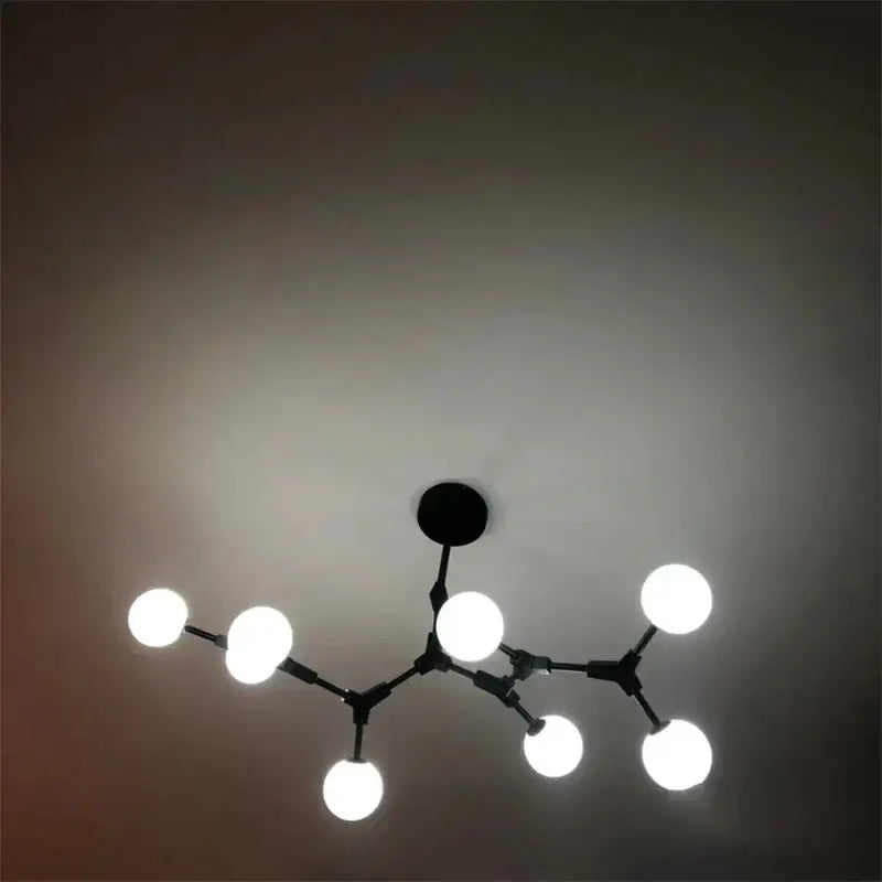 Black metal pendant lights with six glowing white bulbs in an iron magic molecular design for modern decorbites