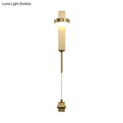 Modern brass l-shaped wall sconce with pull chain featuring a sleek rectangular design for living room use