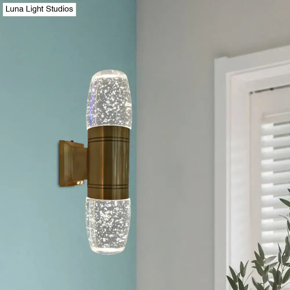 Modern brass led crystal wall sconce light with bubble textured glass sections emitting soft glow for bedroom use