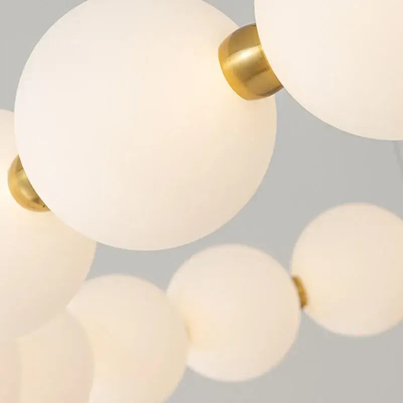 Modern brass led pendant light with frosted white spherical glass globes and polished brass accents for living room decorbites brass led