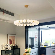 A modern brass led pendant light with frosted glass spheres and gold-toned rods for living room decorbites brass led