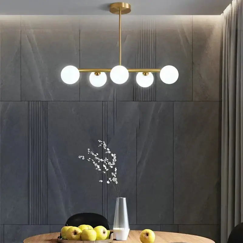 Modern brass led pendant lights featuring five frosted glass globe lights for elegant dining room decorbites brass led chandelier