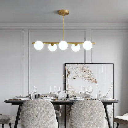 Modern brass led pendant lights featuring five white glass globes in gold-toned brass led pendant design by decorbites