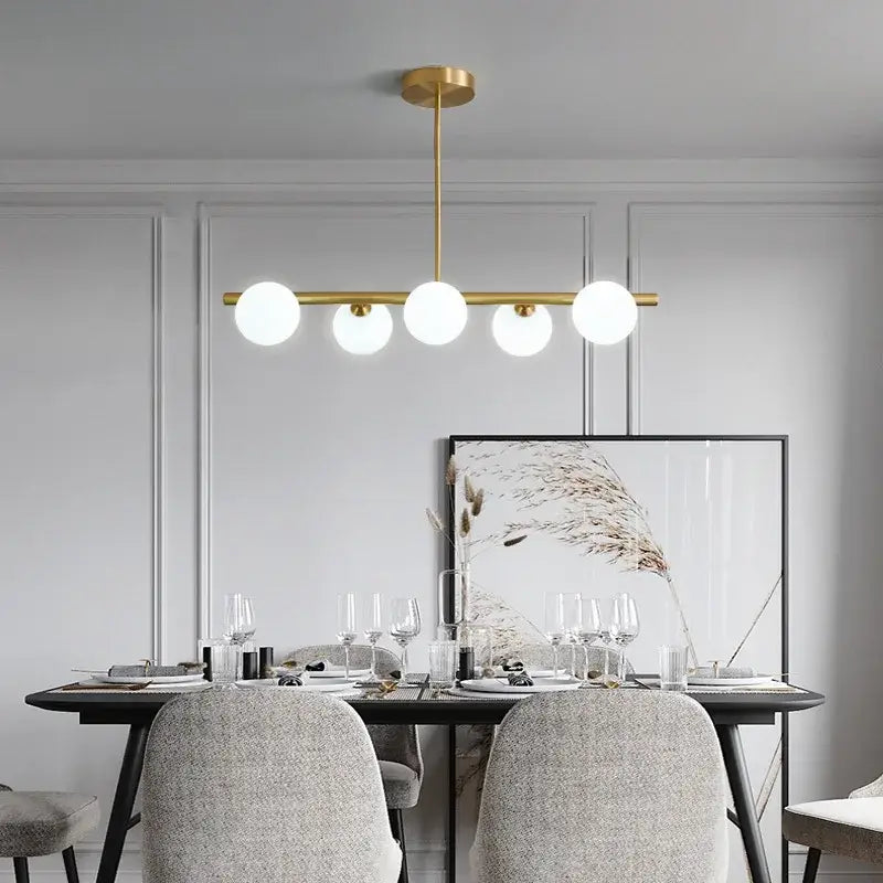 Modern brass led pendant lights featuring five white glass globes in gold-toned brass led pendant design by decorbites