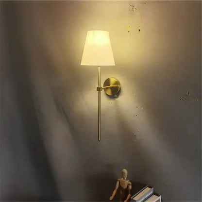 Modern brass led wall sconce with a gold-toned finish and white fabric shade for bedroom decorbites led wall lighting