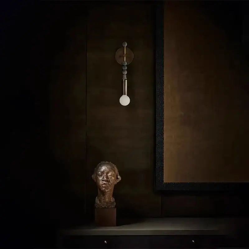 Bronze-colored sculpted bust on dark wooden base complements modern brass marble ball wall sconce bedroom led light decorbites brass marble