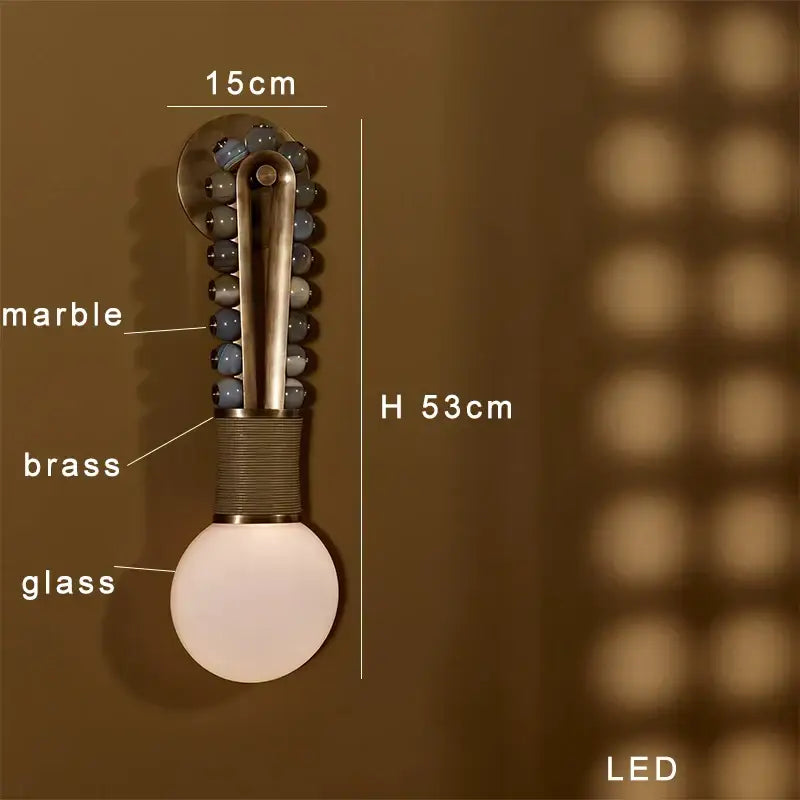 Modern brass marble ball wall sconce with brass stem, blue-gray marble beads, and white glass globe by decorbites