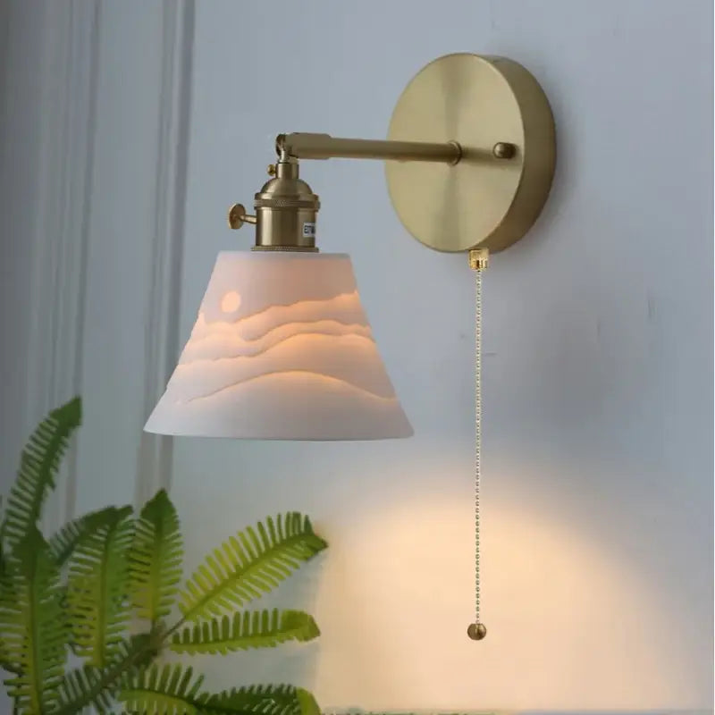 Modern brass mountain led wall lamp sconce with frosted white sculpted glass shade depicting waves and crescent moon