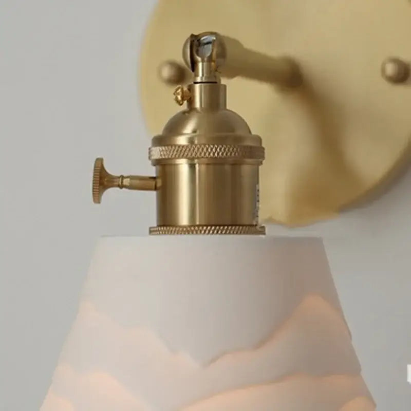 Modern brass mountain led wall lamp sconce with gold-toned brass base and off-white frosted glass shade for bedroom or stairs