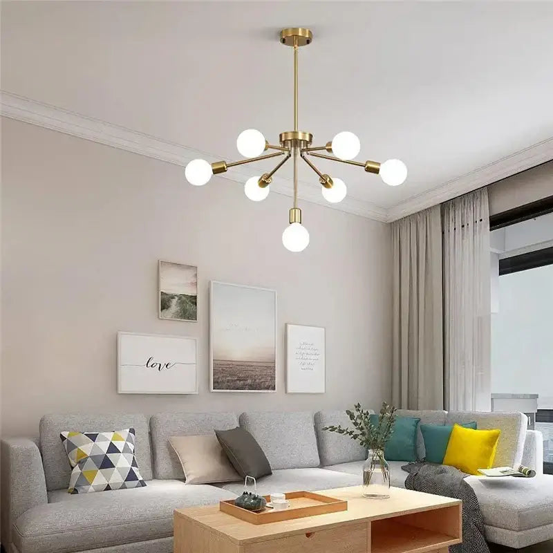 Modern brass nordic ceiling chandelier with six gold-toned frosted glass globe bulbs for living room lighting