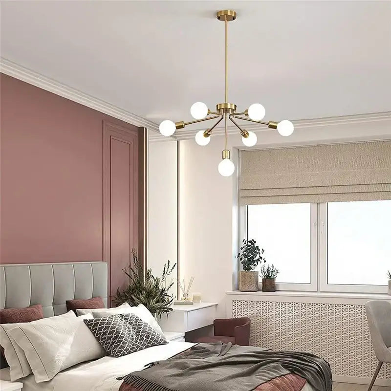 Modern brass nordic ceiling chandelier with six frosted glass globe bulbs in gold tone for living room lighting