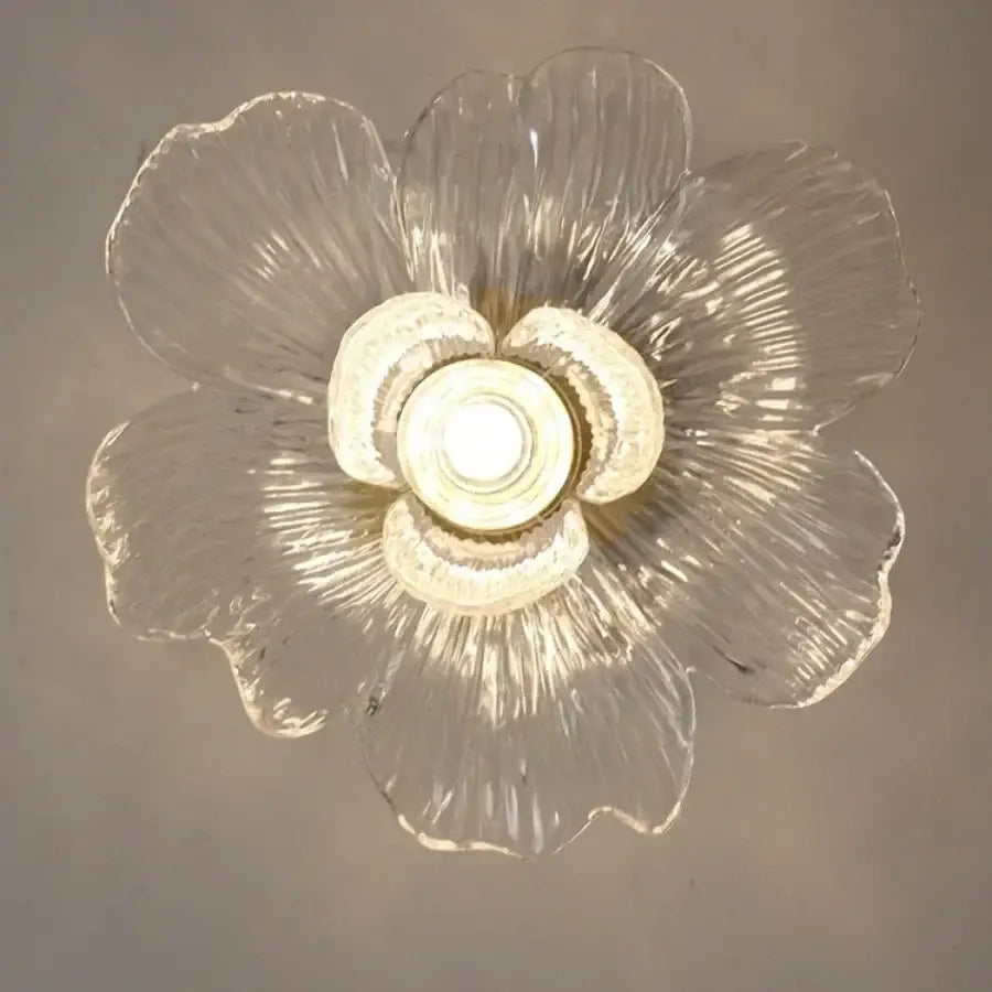 Modern brass orchid clear glass led ceiling lamp with textured flower-shaped petals and central illuminated bulb for bedroom