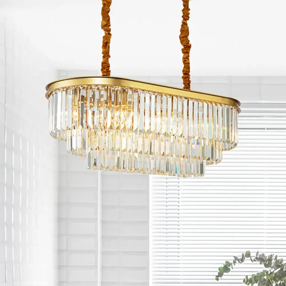 Modern brass oval crystal chandelier with gold-toned frame and cascading prisms for elegant dining room hanging light