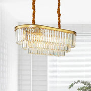 Modern brass oval crystal chandelier with gold-toned frame and cascading prisms for elegant dining room hanging light