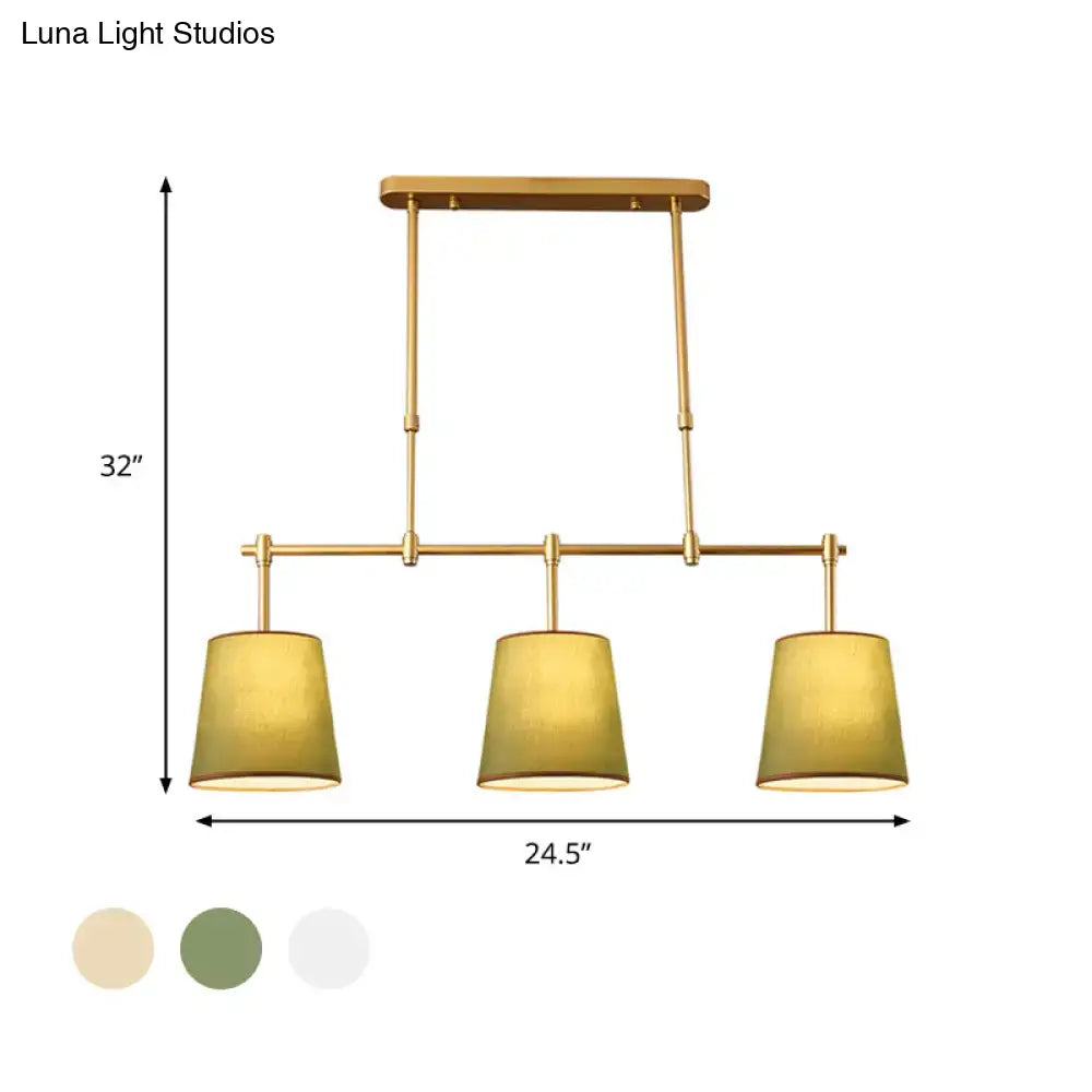 Modern brass pendant light with gold finish and three cylindrical white green flaxen fabric shades for dining room lighting