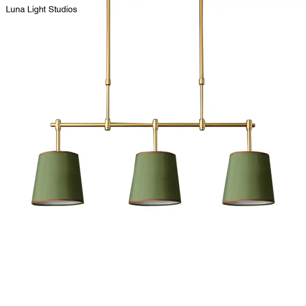 Modern brass pendant light with three olive green fabric shades featuring white green flaxen hues for dining room use