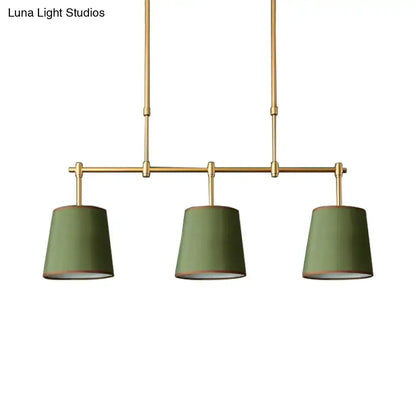 Modern brass pendant light with three olive green fabric shades featuring white green flaxen hues for dining room use