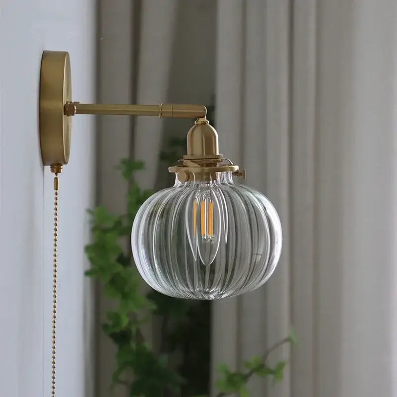 Modern brass ribbed glass ball wall sconce with clear glass globe and brass-finished metal arm for bedroom decorbites glass ball wall