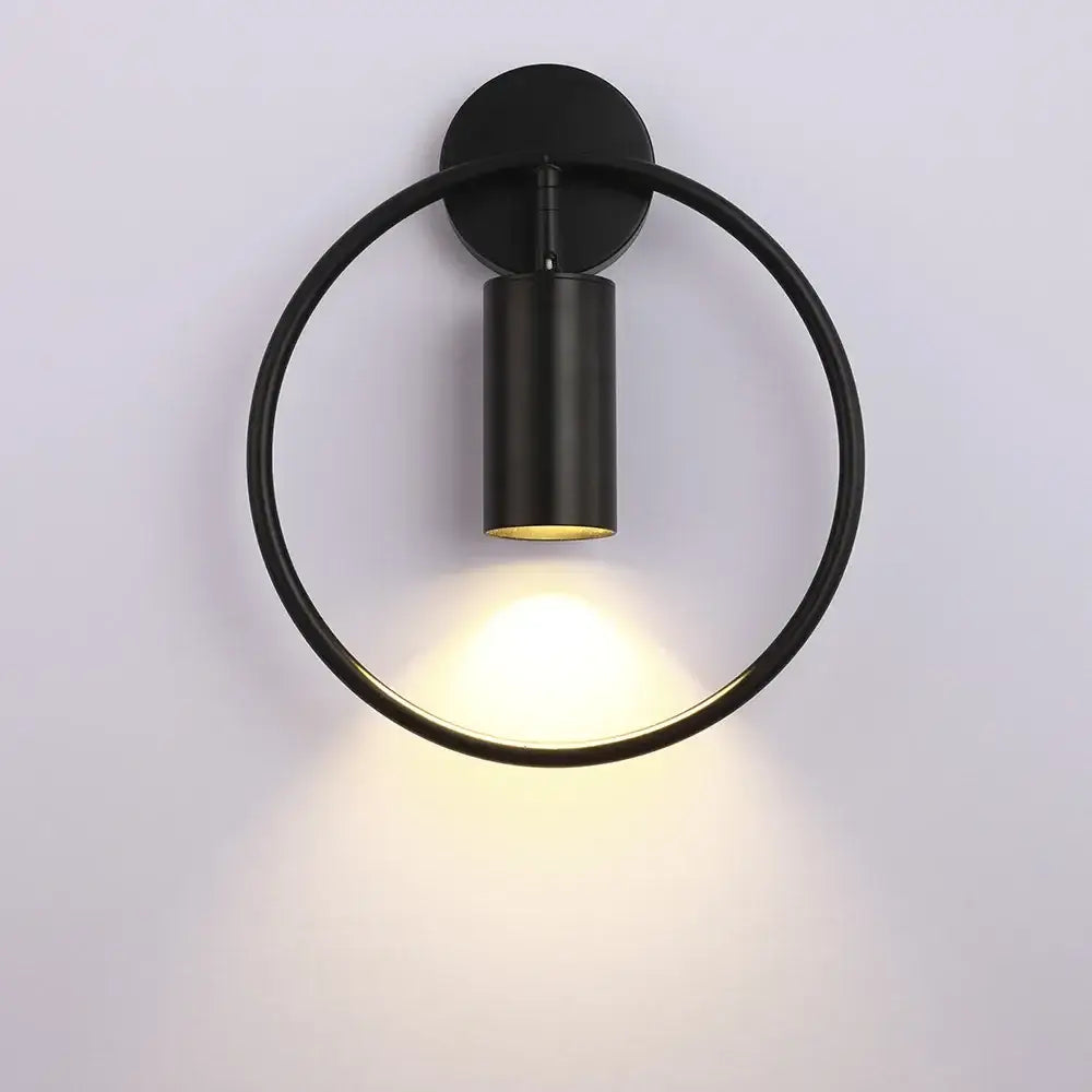 Black circular modern brass ring led wall lamp with matte finish and warm focused light for bedroom sconce