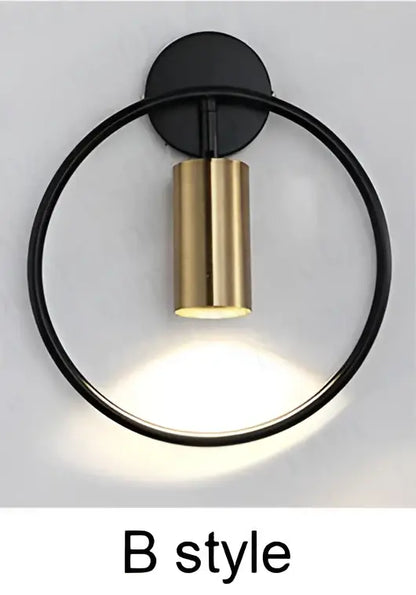 Modern brass ring led wall sconce featuring a black circular base with a gold cylindrical light fixture for bedroom decorbites brass ring design