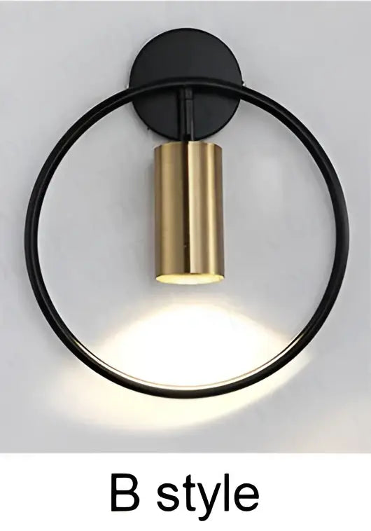 Modern brass ring led wall sconce featuring a black circular base with a gold cylindrical light fixture for bedroom decorbites brass ring design
