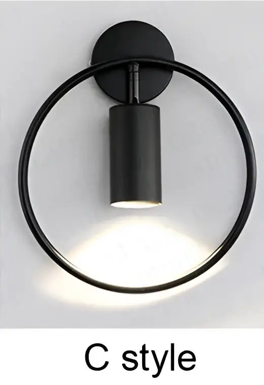Black matte c-style wall sconce with circular ring and cylindrical light featuring decorbites brass ring led design