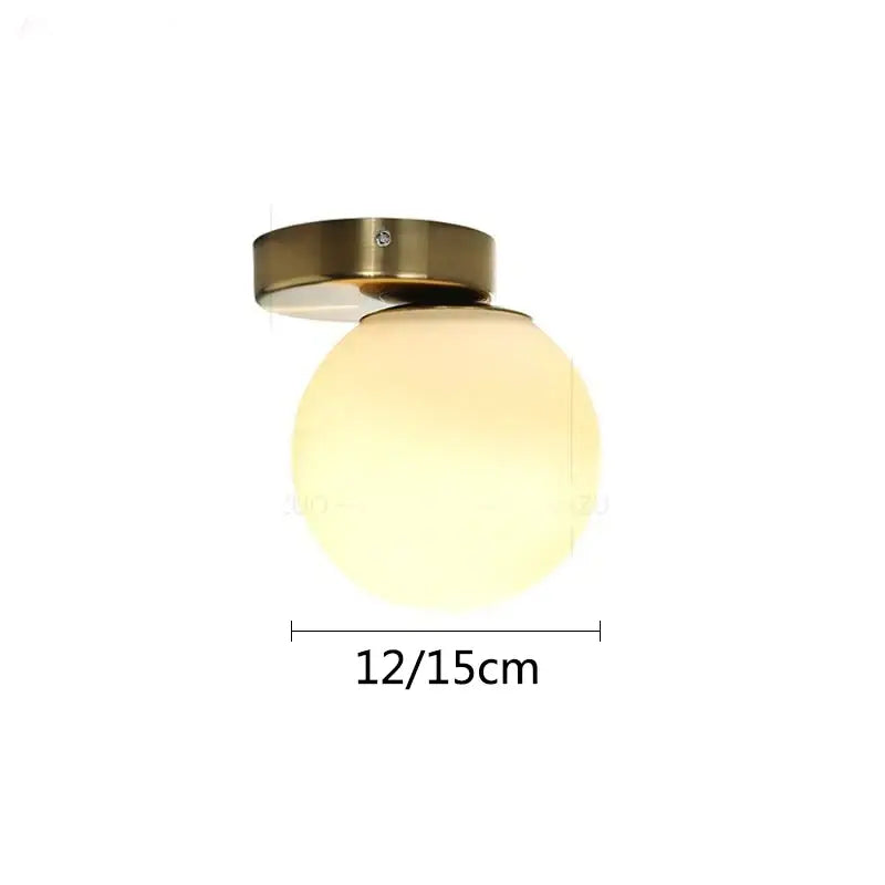 Modern brass round ceiling lamp with a warm frosted glass globe and brushed brass mounting base for hallway lighting