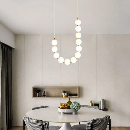 Modern brass round led pendant lights featuring white spherical bulbs and gold-toned fixtures for dining room decorbites brass round chandelier
