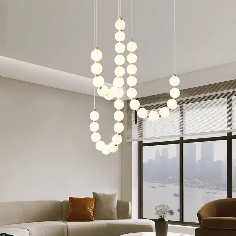 Modern brass round led pendant lights featuring frosted glass spheres and gold-toned metal connectors for dining room decor