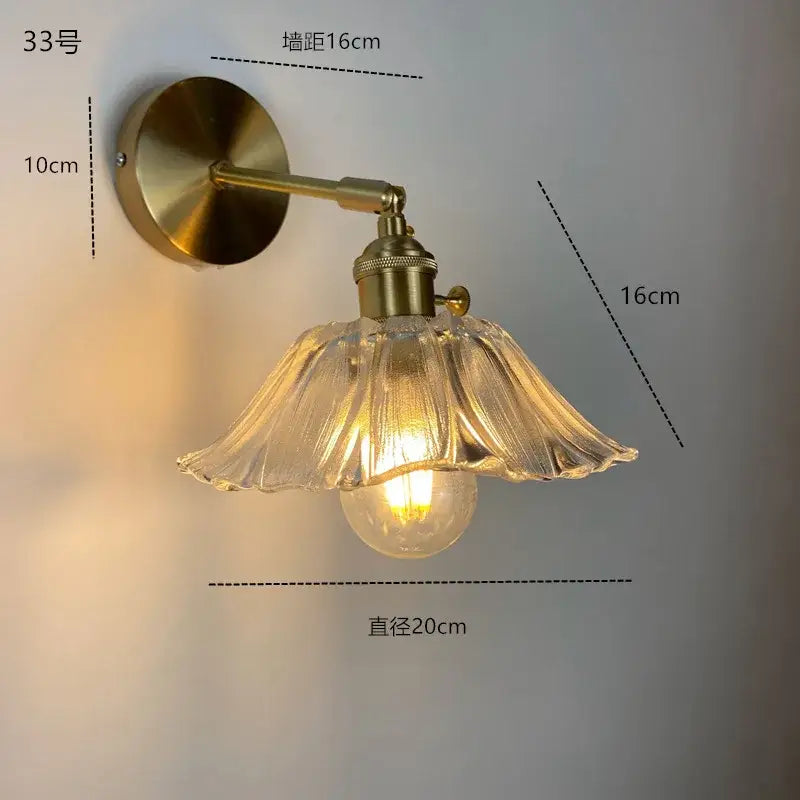 Antique brass-finished wall sconce with a fluted decorbites clear glass led shade and exposed bulb for modern lighting