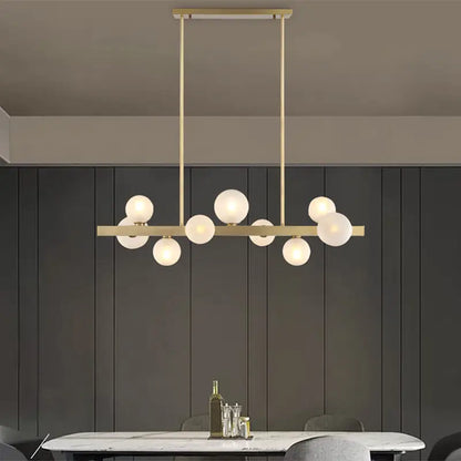 Modern brass simplicity globe pendant with frosted glass bulbs in a linear design for dining room lighting