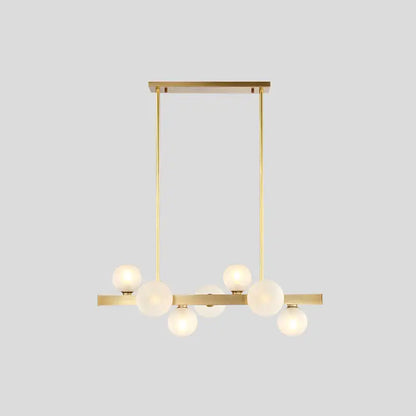 Modern brass simplicity globe pendant dining room light with six frosted glass bulbs in a linear arrangement