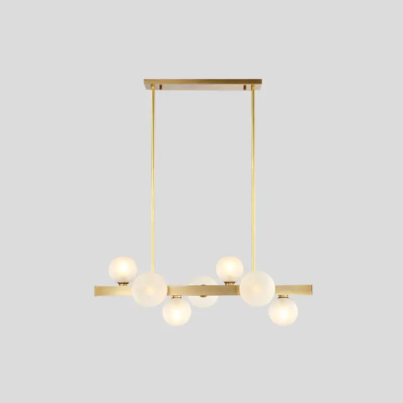 Modern brass simplicity globe pendant dining room light with six frosted glass bulbs in a linear arrangement