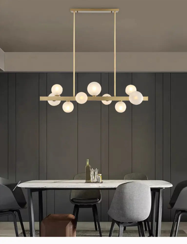 Modern brass simplicity globe pendant light with gold-toned metal and frosted glass bulbs for dining room lighting
