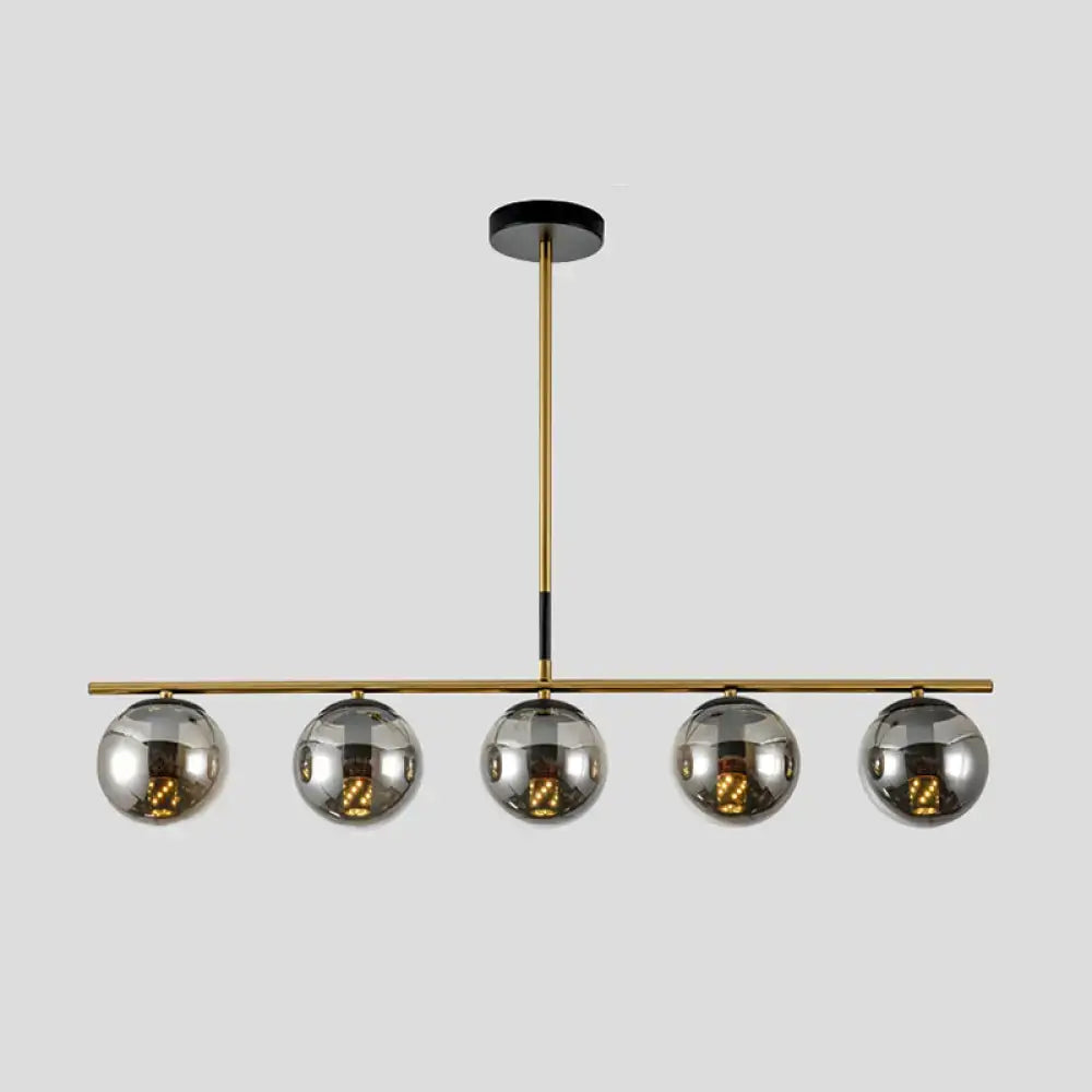 Modern brass smoke grey globe chandelier with five reflective chrome spheres for kitchen island lighting