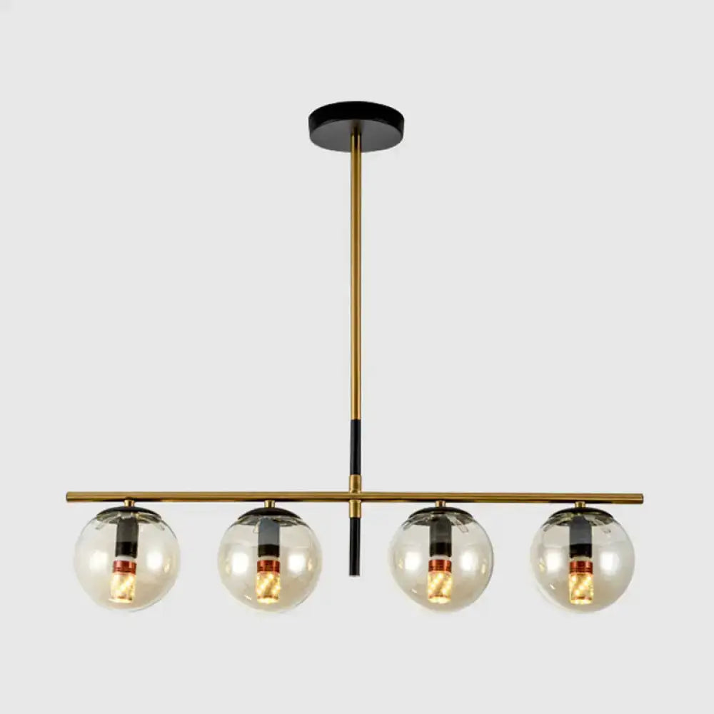 Modern brass and smoke grey pendant light fixture with four clear glass globe bulbs for kitchen island lighting