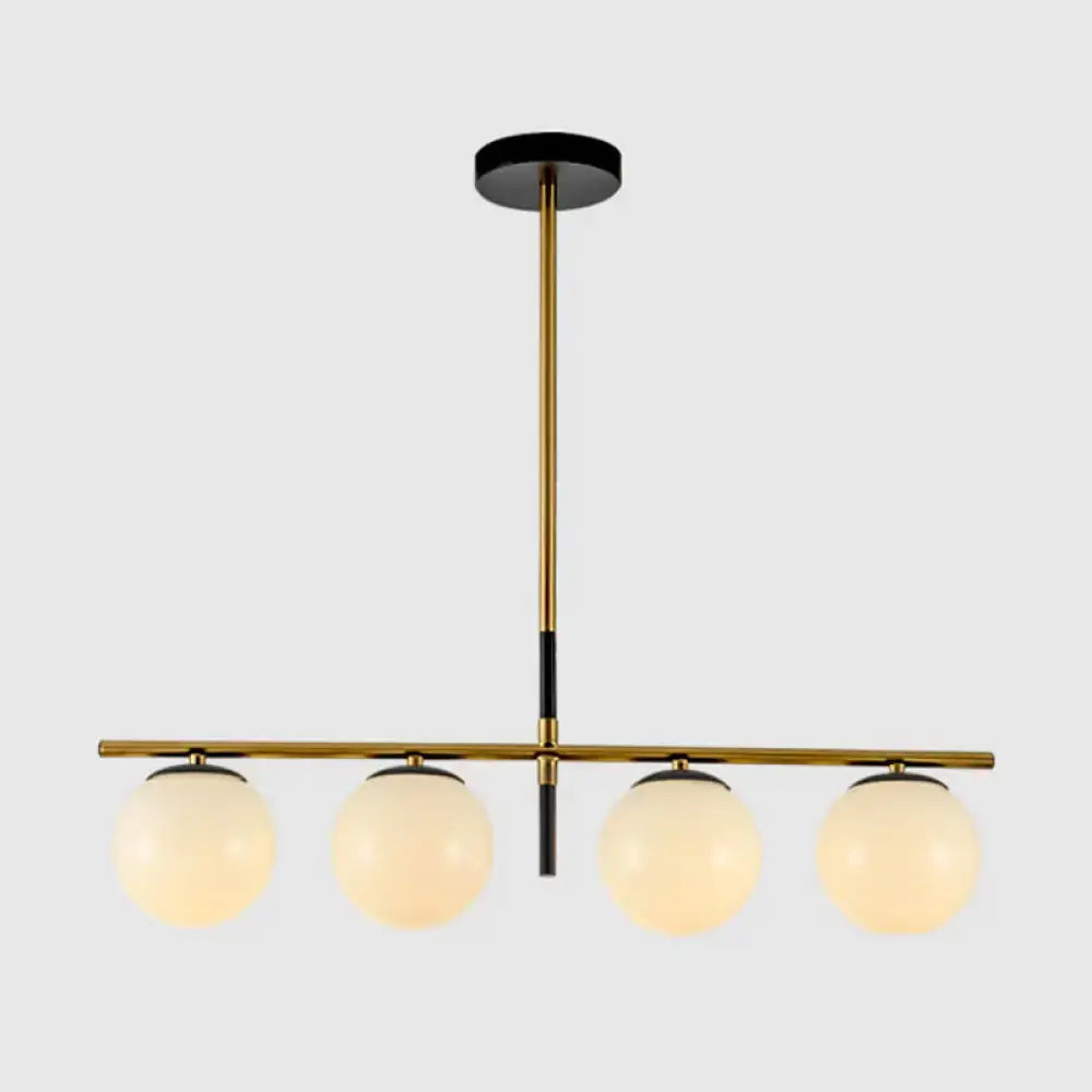 Modern brass and smoke grey pendant light fixture with four frosted glass globe shades for kitchen island lighting