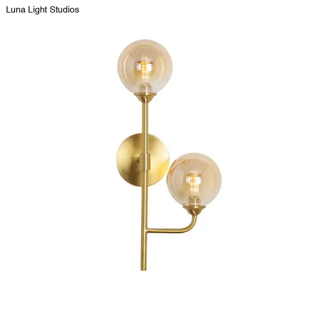 Modern brass sphere wall sconce with two amber smoke gray glass bulbs for bathroom lighting in brass finish