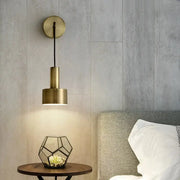 Modern brass wall lamp with a cylindrical brass-finished pendant design mounted on a circular wall sconce decorbites brass wall