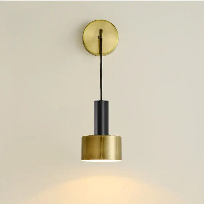 Modern brass wall lamp with black cylindrical shade and circular brass mount for minimalist living room decorbites brass wall lamp