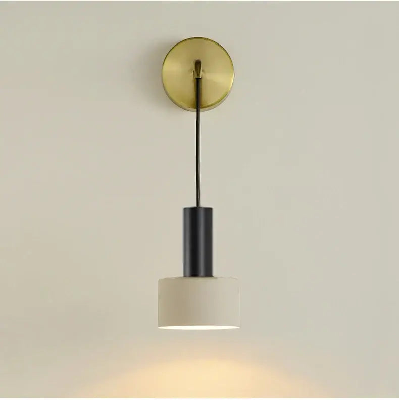 Minimalist wall lamp with brushed brass base, black cylindrical stem, and off-white ceramic shade for modern decorbites brass wall lamp