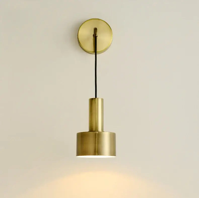 Modern brass wall lamp with a sleek cylindrical design and warm ambient glow ideal for minimalist living room decorbites brass wall