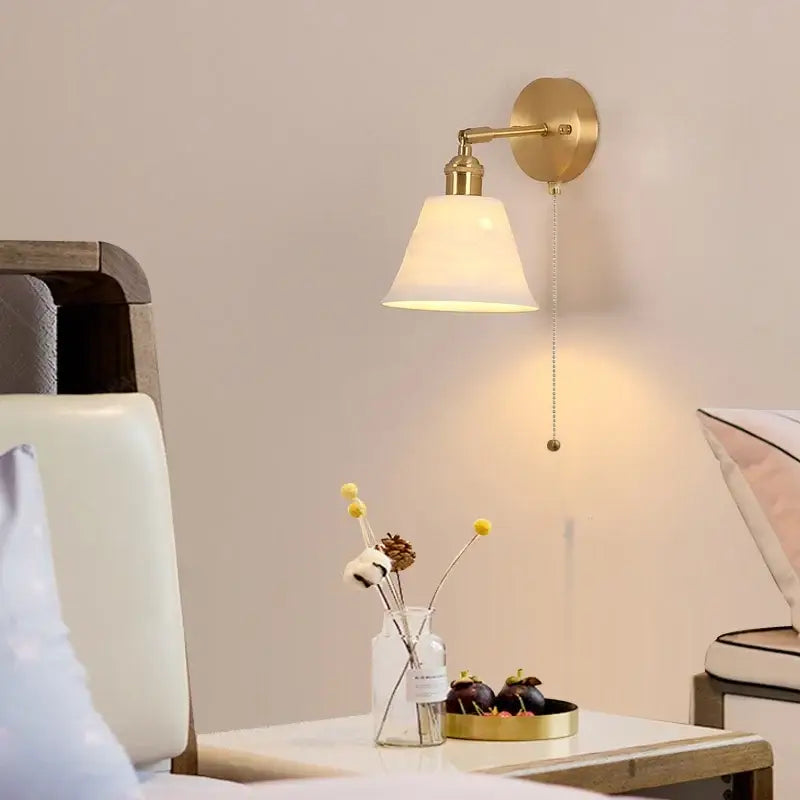 Antique brass-finished wall lamp with frosted ceramic shade and elegant pull-chain switch for bedroom reading decorbites copper led