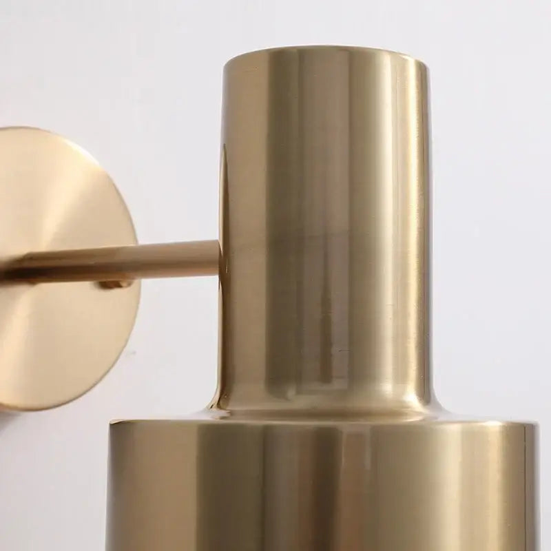 Modern brass wall lamp with pull chain switch featuring a brass-finished cylindrical design for bedroom decor