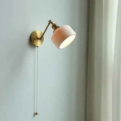 Modern brass wall lamp with a soft peach ribbed glass shade and adjustable decorbites copper arm for bedroom reading light