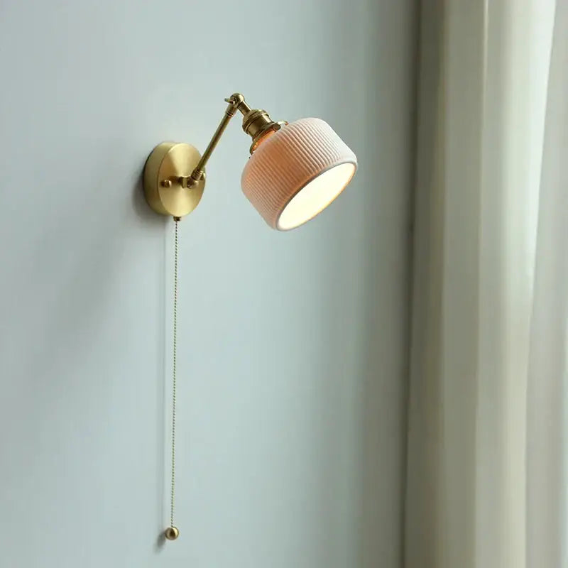 Modern brass wall lamp with a soft peach ribbed glass shade and adjustable decorbites copper arm for bedroom reading light